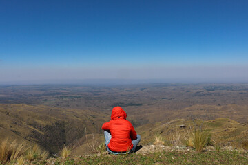 woman sitting on a mountain top peacefully - Cerro champaqui, cordoba, argentina