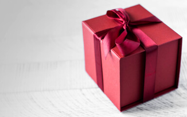 Red gift box on a wooden background. Copy space.