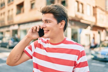 Young caucasian man smiling happy talking on the smartphone at the city.