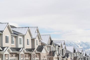 Gabled townhouses with scenic mountain and overcast sky background in winter