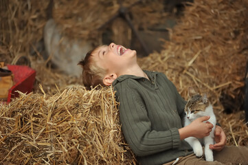Little boy and cat. Child playing with a kitten.