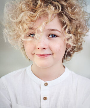 portrait of beautiful happy blonde boy with curly hair