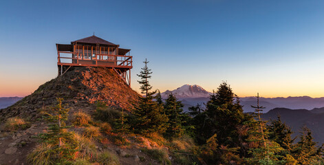 Panoramic view of a fire lookout with mt rainier in the background during the sunset - obrazy, fototapety, plakaty