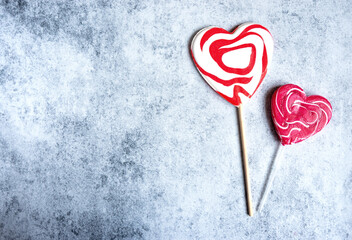 Top view of two heart-shaped lollypops on grey concrete background, Valentine's Day concept, copy...