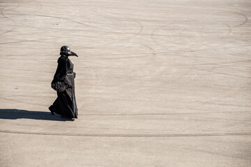 plague doctor alone on a large paved area
