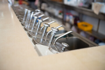 Vintage, chrome, soda fountain pumps in an old diner with selective focus.