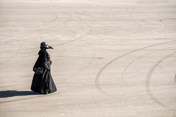 plague doctor alone on a large paved area