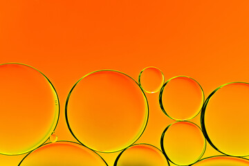 Orange oil drops. Bubbles of different sizes on orange abstract background