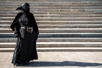 plague doctor in front of the stairs to the top