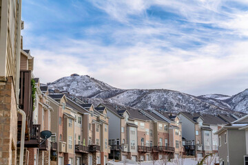 Mountain peak and townhouses against cloudy blue sky background in winter