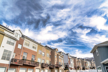 Fototapeta na wymiar Dramatic skyscape of cloudy blue sky over townhouses with Wasatch mountain view