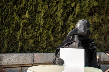 plague doctor holds a tablet