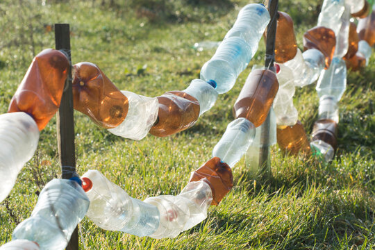 A fence made from old plastic bottles. Recycling and processing of inorganic waste.