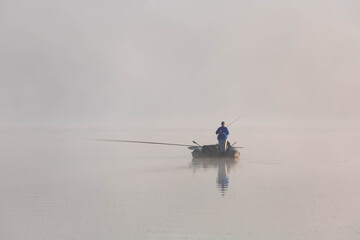 Fishing boat on the lake in the morning. Morning mist. Copy space