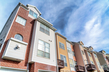 Exterior of houses with dormers and balconies beneath scenic skyscape view