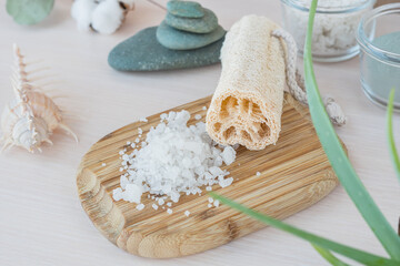 Spa concept with loofah, stones and towel. Beauty eco cosmetics zero waste, spa setting, composition with Dead sea salt, coconut,  natural cosmetic blue clay, soda, loofah. Flat lay.