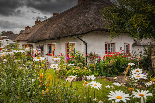 Adare, Ireland. Thatched cottage in the picturesque Village of Adare, Co. Limerick full of flowers in front garden 2019 Ireland, Europe