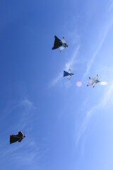 Wingsuit fliers glide in formation, under view to sky above