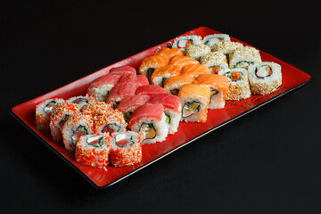 Asian cuisine dish, delicious sushi, sushi on a black background, roll you net on a black background
