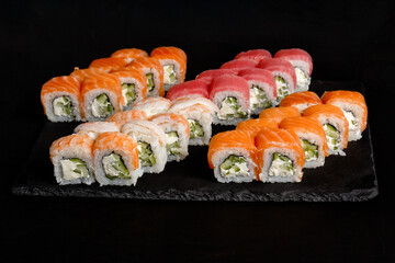 Asian cuisine dish, delicious sushi, sushi on a black background, roll you net on a black background,