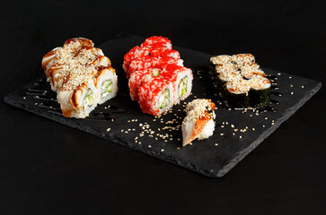 Asian cuisine dish, delicious sushi, sushi on a black background, roll you net on a black background,