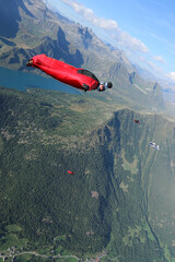 Wingsuit flier with camera mount glides high above land