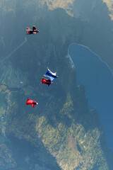Wingsuit fliers glide in formation at sunrise