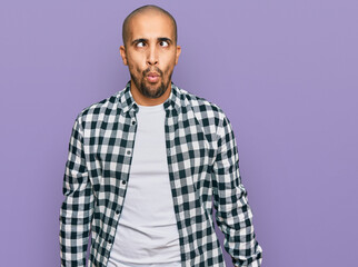 Hispanic adult man wearing casual clothes making fish face with lips, crazy and comical gesture. funny expression.