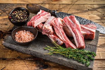 Sliced lamb short spare loin ribs, raw meat on a wooden cutting board. Wooden background. Top view