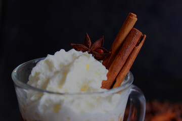 frothy coffee drink. Cappuccino or latte in a transparent glass on a dark background.