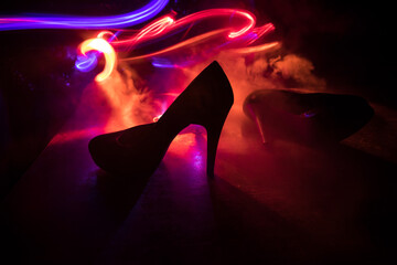 Silhouette of a high heel women shoes at dark. Women power or women domination concept.