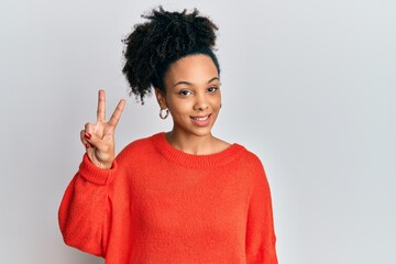 Young african american girl wearing casual clothes showing and pointing up with fingers number two while smiling confident and happy.