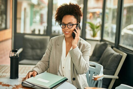 Young african american businesswoman smiling happy talking on the smartphone sitting at coffee shop.