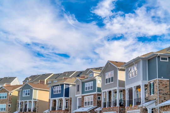 Homes in the valley on a sunny day setting beneath vibrant blue sky and clouds