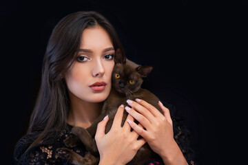 Obraz premium Young beautiful sexy woman with bright makeup with a cat in her hands