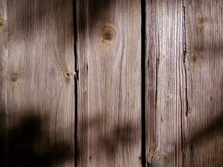 Naklejka premium background light shadow on a wooden wall close up with leaves falling shadow
