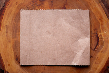 Mockup of vintage white paper list at textured wooden table background.