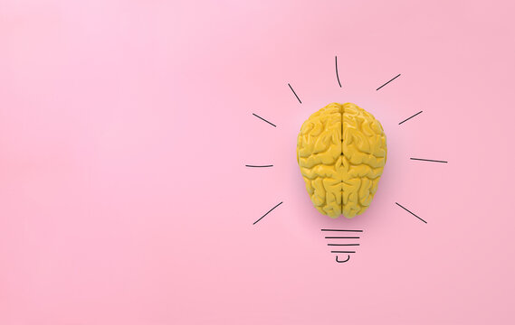 Yellow brain on pink background, concept light bulb idea with pencil drawing. Space for text.