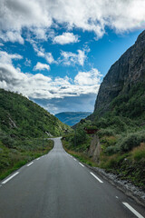 Street through a hilly landscape with green spots