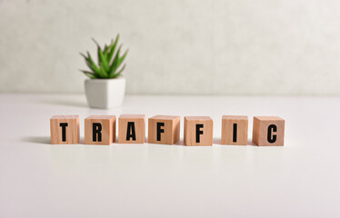 The word traffic written on wooden cubes with exchange icons on yellow background. Trade in business market concept