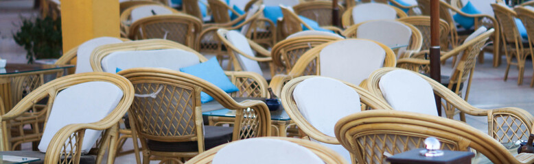 Outdoor french traditional cafe with old wood tables and wicker chairs banner