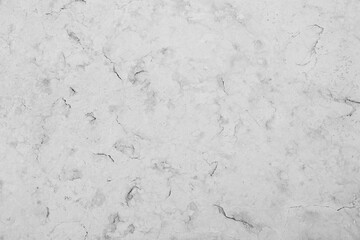 Close-up of an aged and cracked smooth natural marble stone wall or flooring. High resolution full frame textured background in black and white.