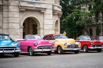colorful classic cars in front of historic building on the streets of havana cuba