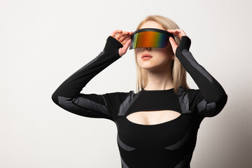 Blonde android female in VR glasses and suit on white background.