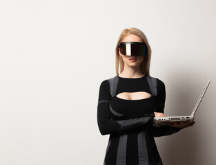 Blonde android female in VR glasses and laptop on white background.