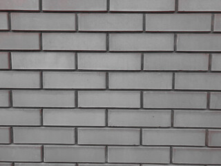 A solid piece of gray brick wall. brickwork for background or texture, colored highlights of light on brickwork