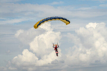 Parasailor glides above lofty clouds