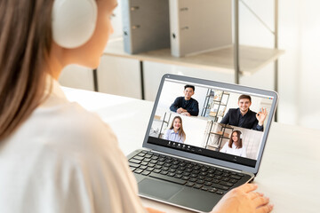 Fototapeta na wymiar Online chat. Virtual teamwork. Professional videocall. Covid-19 WFH. Diverse multiracial colleagues in headphones discussing business project on laptop at light modern home office.