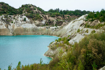 Turquoise chalk quarry. The chalk coast with the growing greenery.