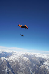 Naklejka na ściany i meble Wingsuit fliers glide over Swiss Alps